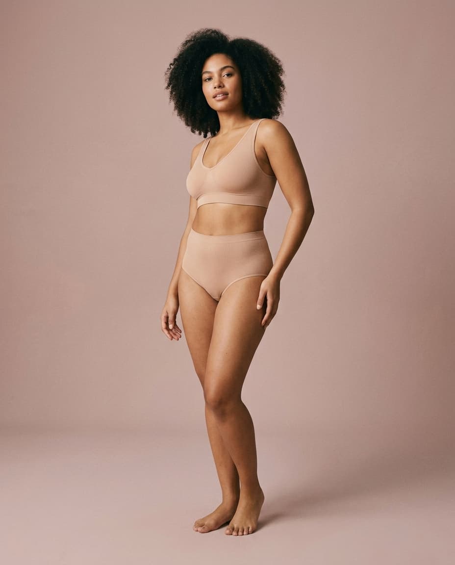 Woman standing by window wearing LIVRA underwear